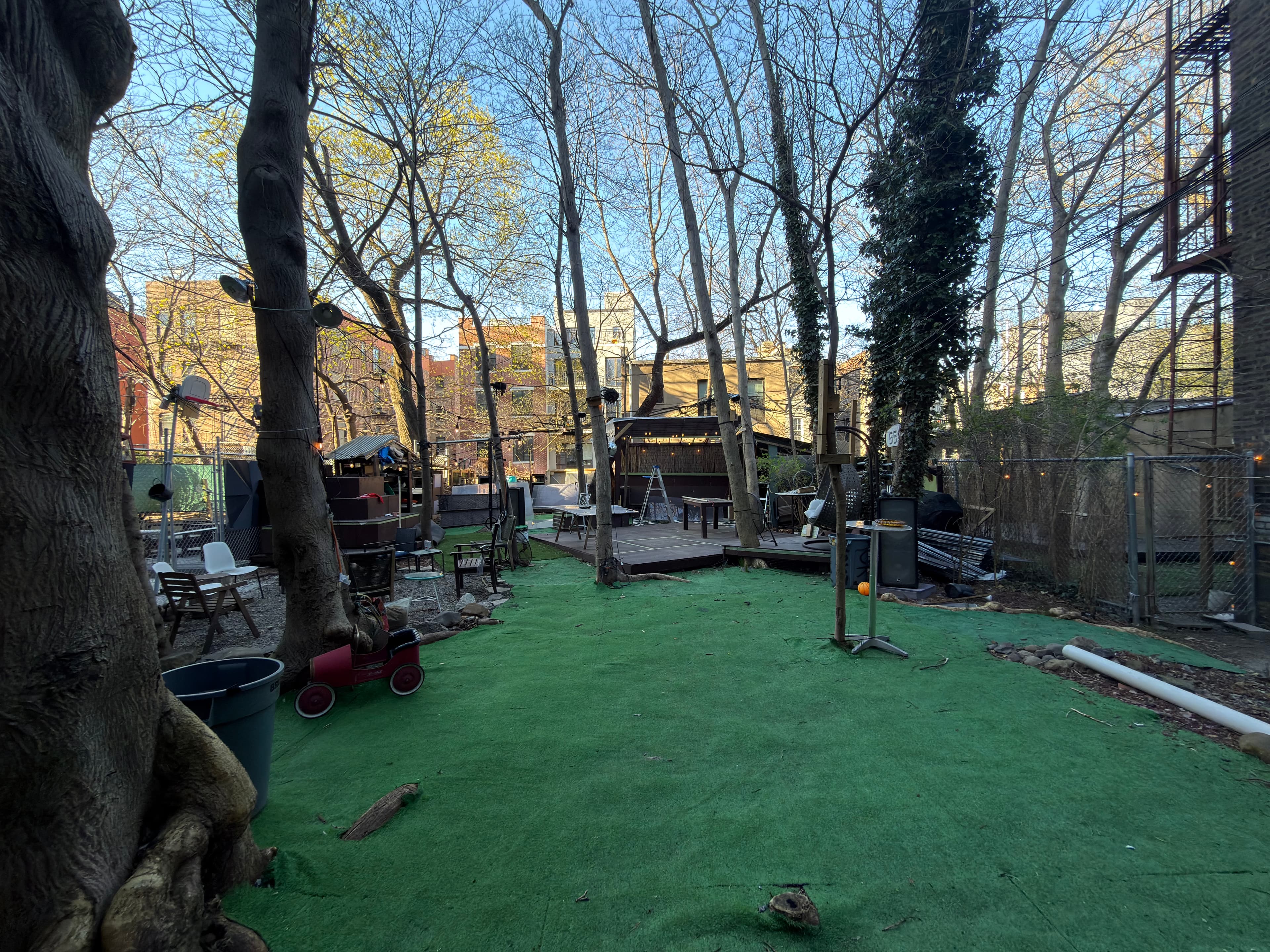Yard 559 during the day — green turf, mature trees, and the stage deck